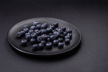 Taze yaban mersinleri ve siyah beton bir arka plan. Mevsimlik böğürtlen toplamak