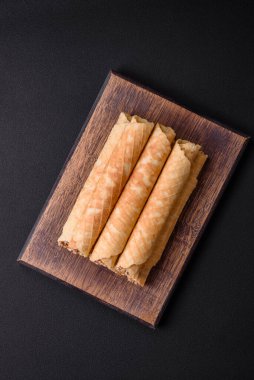 Lezzetli gevrek gofretler, koyu beton arka planda fındıkla dolu kremalı.