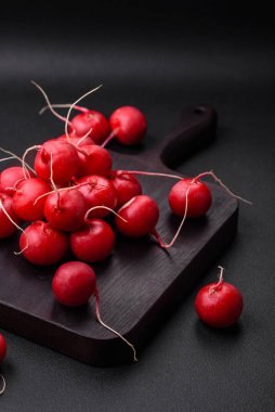 Koyu beton arka planda sağlıklı salata yapmak için lezzetli taze kırmızı turp.