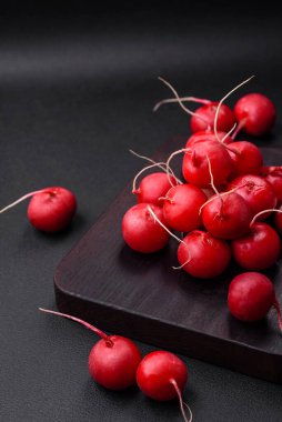 Koyu beton arka planda sağlıklı salata yapmak için lezzetli taze kırmızı turp.