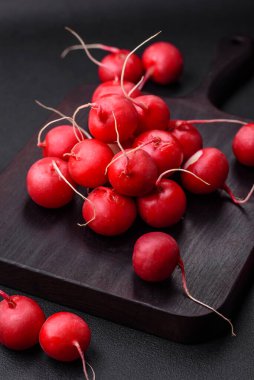 Koyu beton arka planda sağlıklı salata yapmak için lezzetli taze kırmızı turp.