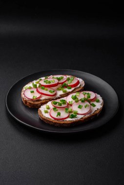 Lezzetli sandviç ya da krem peynirli turp ve koyu betondan yapılmış yeşil soğanlı bruschetta.