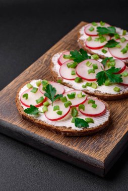 Lezzetli sandviç ya da krem peynirli turp ve koyu betondan yapılmış yeşil soğanlı bruschetta.