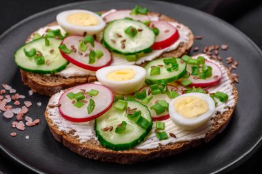 Lezzetli sandviç ya da krem peynirli turp ve koyu betondan yapılmış yeşil soğanlı bruschetta.