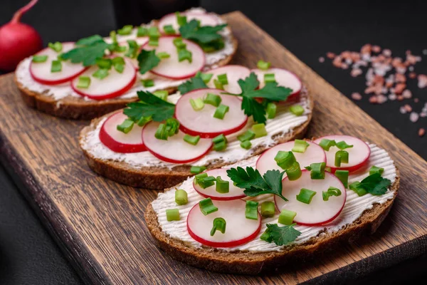 Lezzetli sandviç ya da krem peynirli turp ve koyu betondan yapılmış yeşil soğanlı bruschetta.