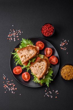 Izgara tost, mozzarella, marul ve domatesli koyu beton kapuçino sandviçi.