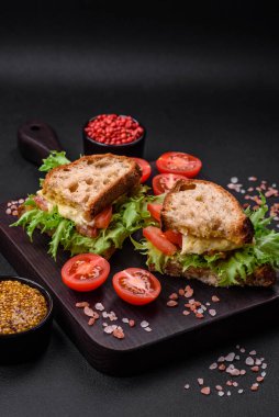 Izgara tost, mozzarella, marul ve domatesli koyu beton kapuçino sandviçi.