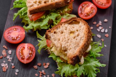 Izgara tost, mozzarella, marul ve domatesli koyu beton kapuçino sandviçi.