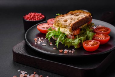 Izgara tost, mozzarella, marul ve domatesli koyu beton kapuçino sandviçi.