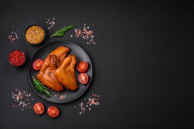 Lezzetli ızgara tavuk kanatları. Baharatlar ve otlarla birlikte. Koyu beton bir arka plan.