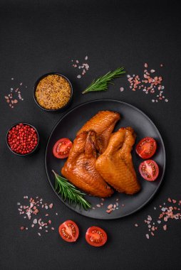 Lezzetli ızgara tavuk kanatları. Baharatlar ve otlarla birlikte. Koyu beton bir arka plan.