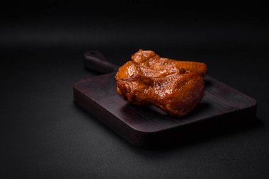 Lezzetli ızgara tavuk kanatları. Baharatlar ve otlarla birlikte. Koyu beton bir arka plan.