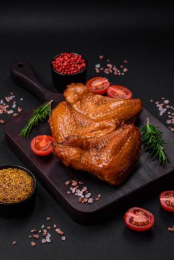 Lezzetli ızgara tavuk kanatları. Baharatlar ve otlarla birlikte. Koyu beton bir arka plan.