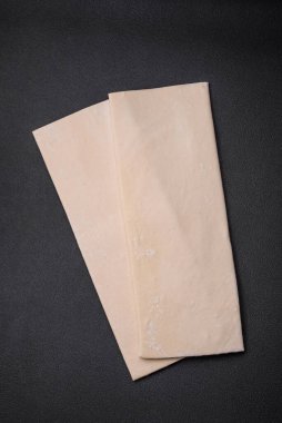 Koyu beton arka planda çiğ puf böreği. Evde tatlı hamur işleri pişiriyorum.