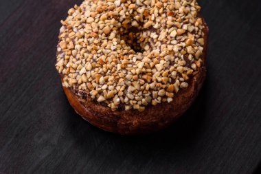 Krema dolgulu lezzetli çörek ve koyu beton arka planda fındık. Tatlı abur cubur