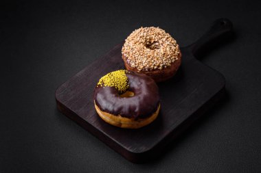 Krema dolgulu lezzetli çörek ve koyu beton arka planda fındık. Tatlı abur cubur