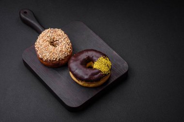 Krema dolgulu lezzetli çörek ve koyu beton arka planda fındık. Tatlı abur cubur