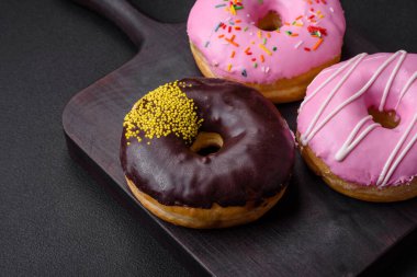 Krema dolgulu lezzetli çörek ve koyu beton arka planda fındık. Tatlı abur cubur