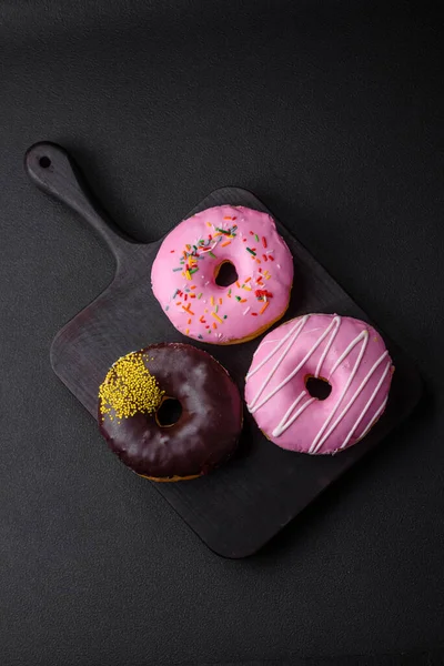 stock image Delicious donut with cream filling and nuts on a dark concrete background. Sweet junk food