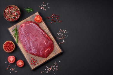 Taze çiğ et, tuz, baharat ve çimento arka planda bitkiler.