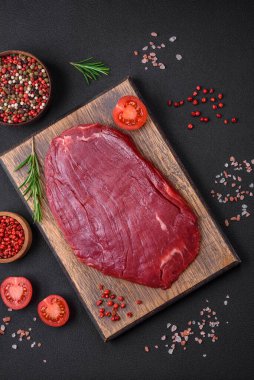 Taze çiğ et, tuz, baharat ve çimento arka planda bitkiler.