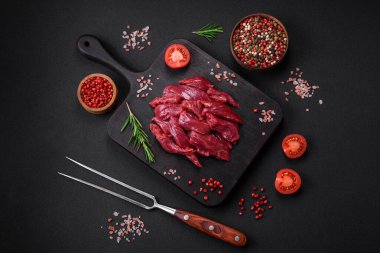 Taze çiğ et, tuz, baharat ve çimento arka planda bitkiler.