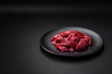 Taze çiğ et, tuz, baharat ve çimento arka planda bitkiler.