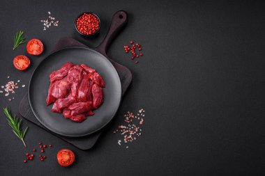 Taze çiğ et, tuz, baharat ve çimento arka planda bitkiler.