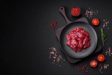 Taze çiğ et, tuz, baharat ve çimento arka planda bitkiler.