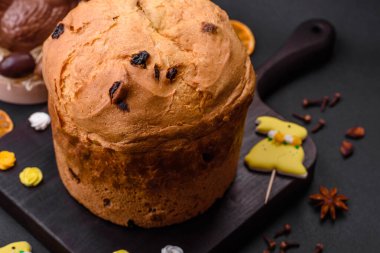 Paskalya pastası veya kuru üzümlü panettone ve koyu beton arka planda şekerli meyveler.
