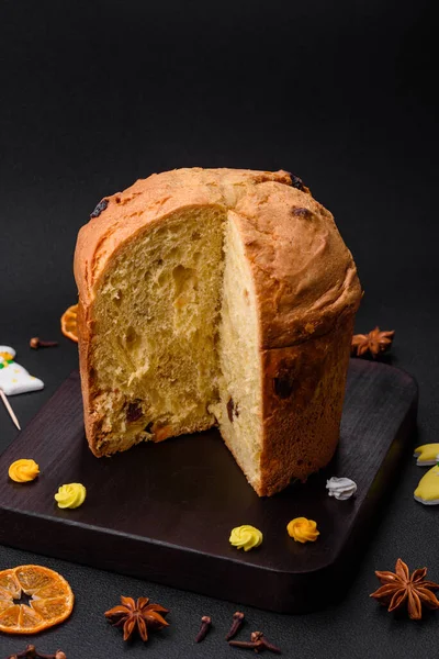 Paskalya pastası veya kuru üzümlü panettone ve koyu beton arka planda şekerli meyveler.