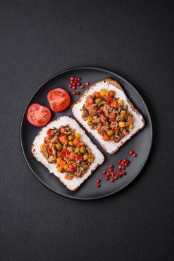 Konserve ton balıklı lezzetli vejetaryen sandviçler ve koyu beton arka planda Meksika karışık sebzeleri.