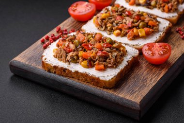 Konserve ton balıklı lezzetli vejetaryen sandviçler ve koyu beton arka planda Meksika karışık sebzeleri.