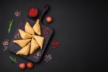 Eti, tuzu ve baharatı koyu beton arka planda üçgen şeklinde leziz krepler.