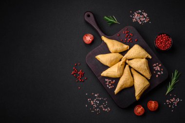 Eti, tuzu ve baharatı koyu beton arka planda üçgen şeklinde leziz krepler.