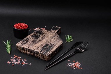 Koyu beton arka planda boş tahta kesme tahtası. Mutfak masasını evde yemek yapmaya hazırlıyorum.