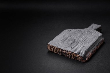 Koyu beton arka planda boş tahta kesme tahtası. Mutfak masasını evde yemek yapmaya hazırlıyorum.