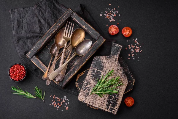 stock image Vintage rectangular shabby wooden box with spoons and forks on a dark concrete background