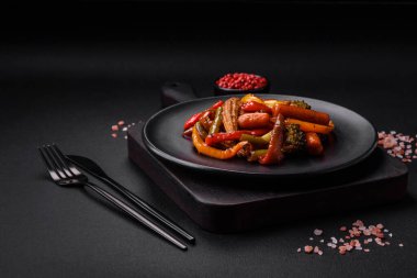 Sebze karışımı mısır, havuç, biber, brokoli, teriyaki soslu soğan koyu beton arka planda seramik bir tabakta