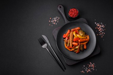 Sebze karışımı mısır, havuç, biber, brokoli, teriyaki soslu soğan koyu beton arka planda seramik bir tabakta