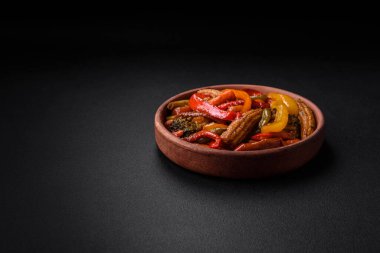 Sebze karışımı mısır, havuç, biber, brokoli, teriyaki soslu soğan koyu beton arka planda seramik bir tabakta