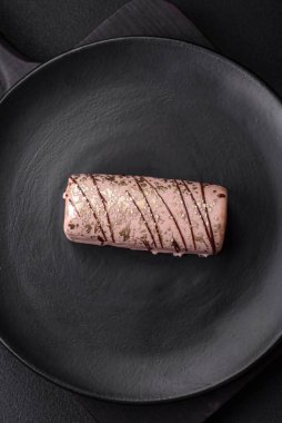 Çikolatayla kaplanmış lezzetli tatlı peynir ve koyu beton arka planda seramik tabakta fındık.