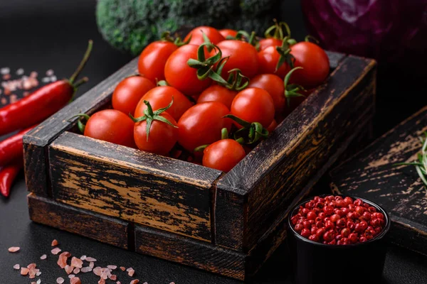 stock image Fresh red cherry tomatoes in a wooden vintage box on a dark concrete background