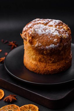 Taze meyveli lezzetli noel pastası ve koyu beton arka planda üzümlü panettone.