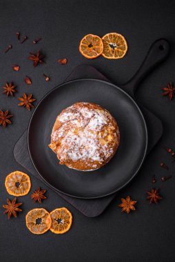 Taze meyveli lezzetli noel pastası ve koyu beton arka planda üzümlü panettone.