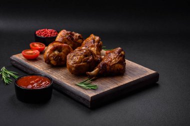 Lezzetli ızgara tavuk bacağı. Baharatlı ve otlu teriyaki soslu. Koyu beton arka planda.