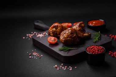 Lezzetli ızgara tavuk bacağı. Baharatlı ve otlu teriyaki soslu. Koyu beton arka planda.