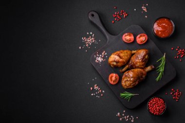 Lezzetli ızgara tavuk bacağı. Baharatlı ve otlu teriyaki soslu. Koyu beton arka planda.