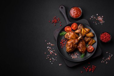 Lezzetli ızgara tavuk bacağı. Baharatlı ve otlu teriyaki soslu. Koyu beton arka planda.