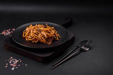 Lezzetli erişte ya da mantarlı udon, tuz, baharat ve otlar koyu beton bir zeminde seramik bir tabakta.